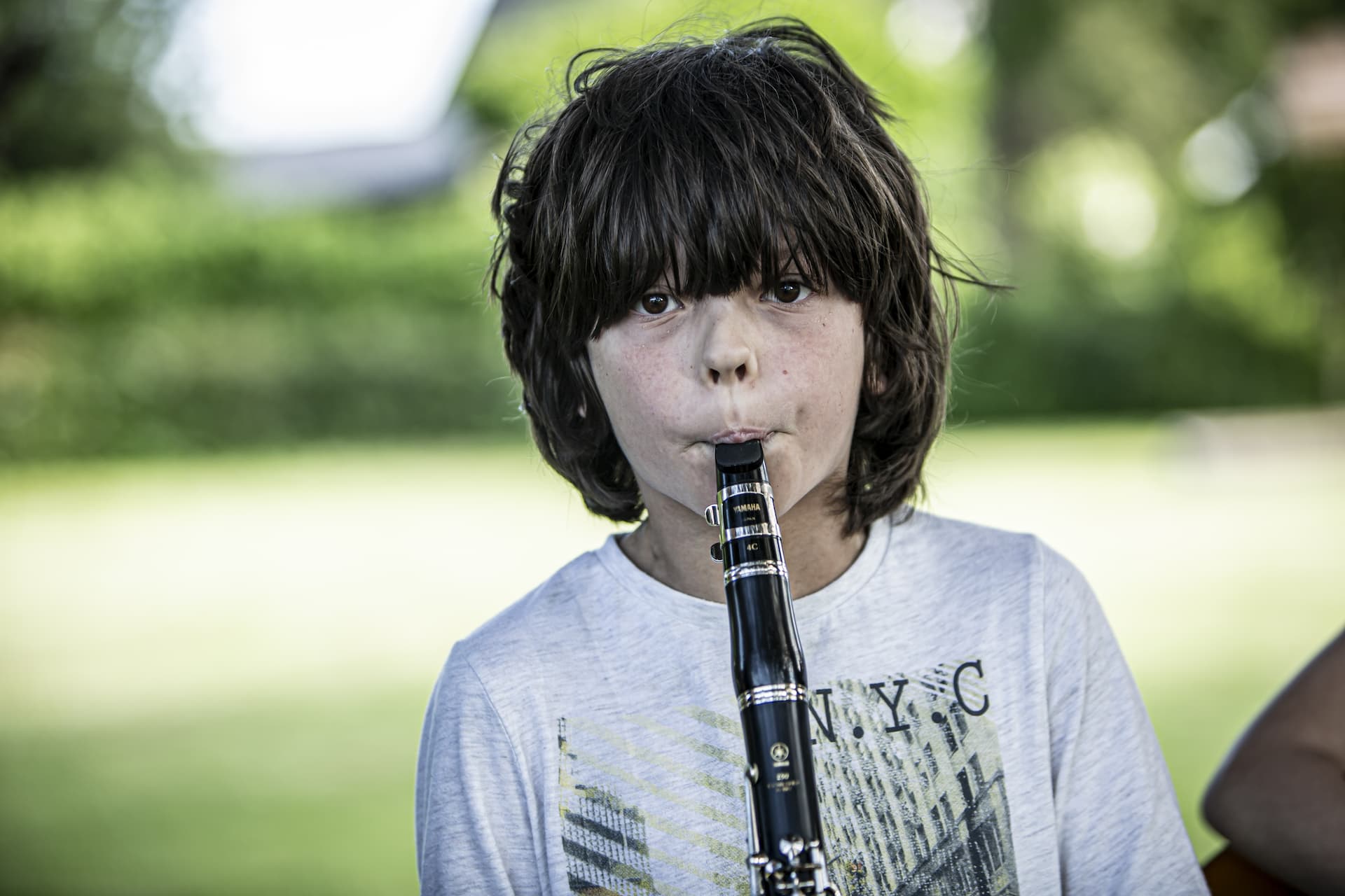 En dreng med meget hår spiller klarinet