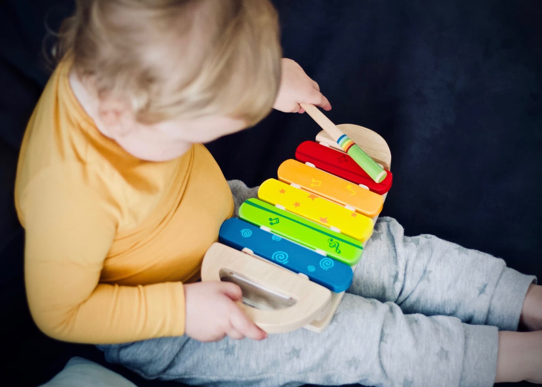 Minimus-elev spiller på regnbuefarvet børneinstrument